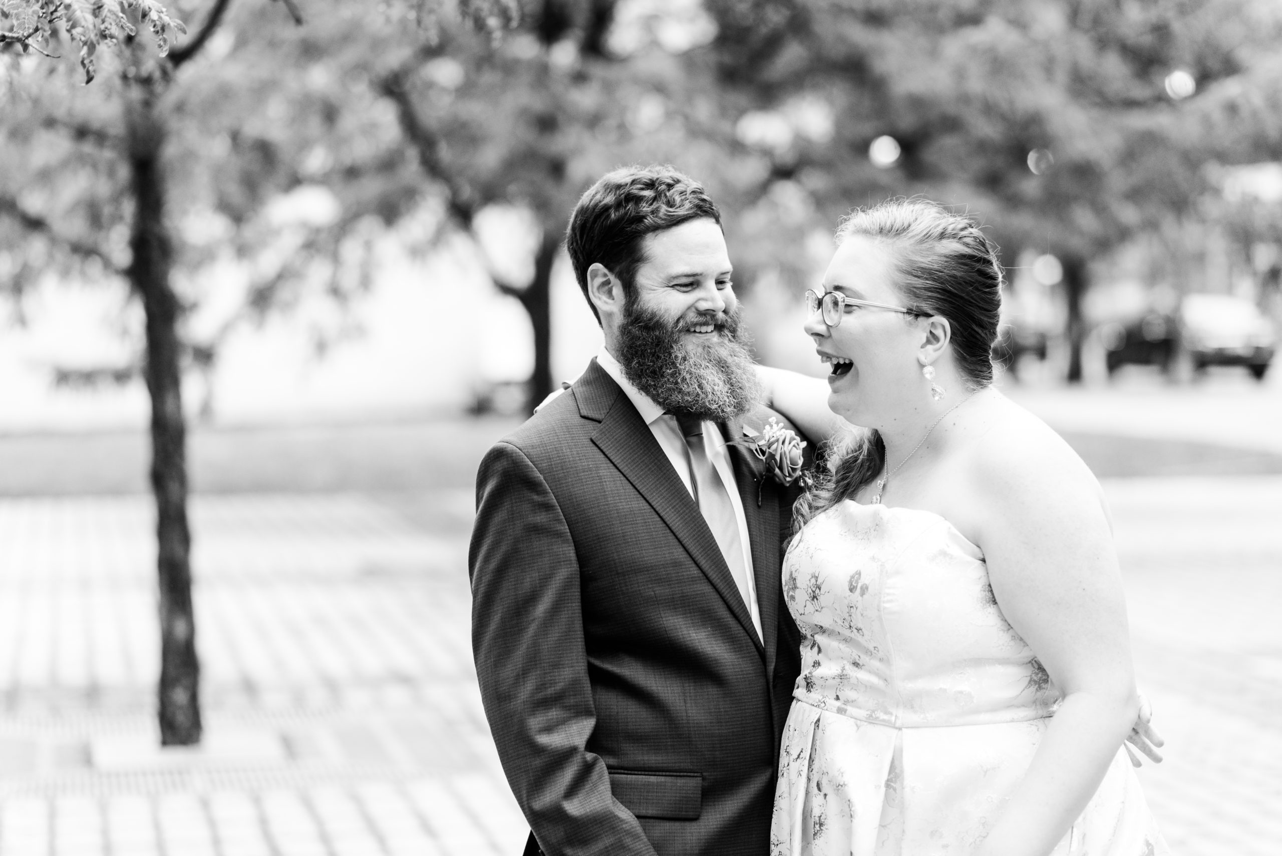 black and white photo of bride & groom laughing